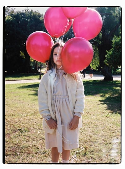 A person holding a bunch of balloons

Description automatically generated with medium confidence