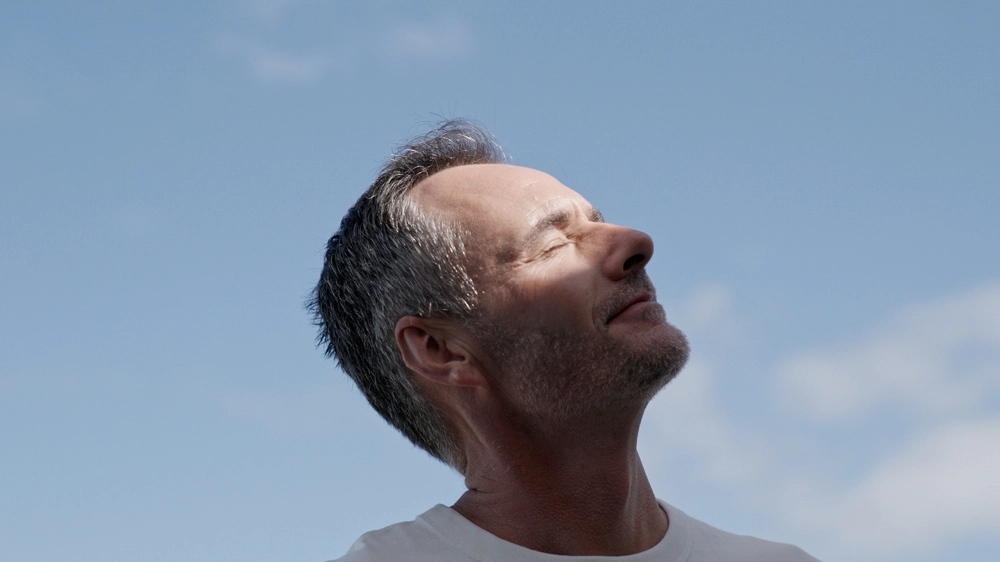 Male model looking up into the sun