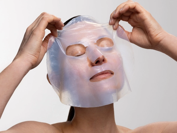 Model applying Sheet Mask to her face