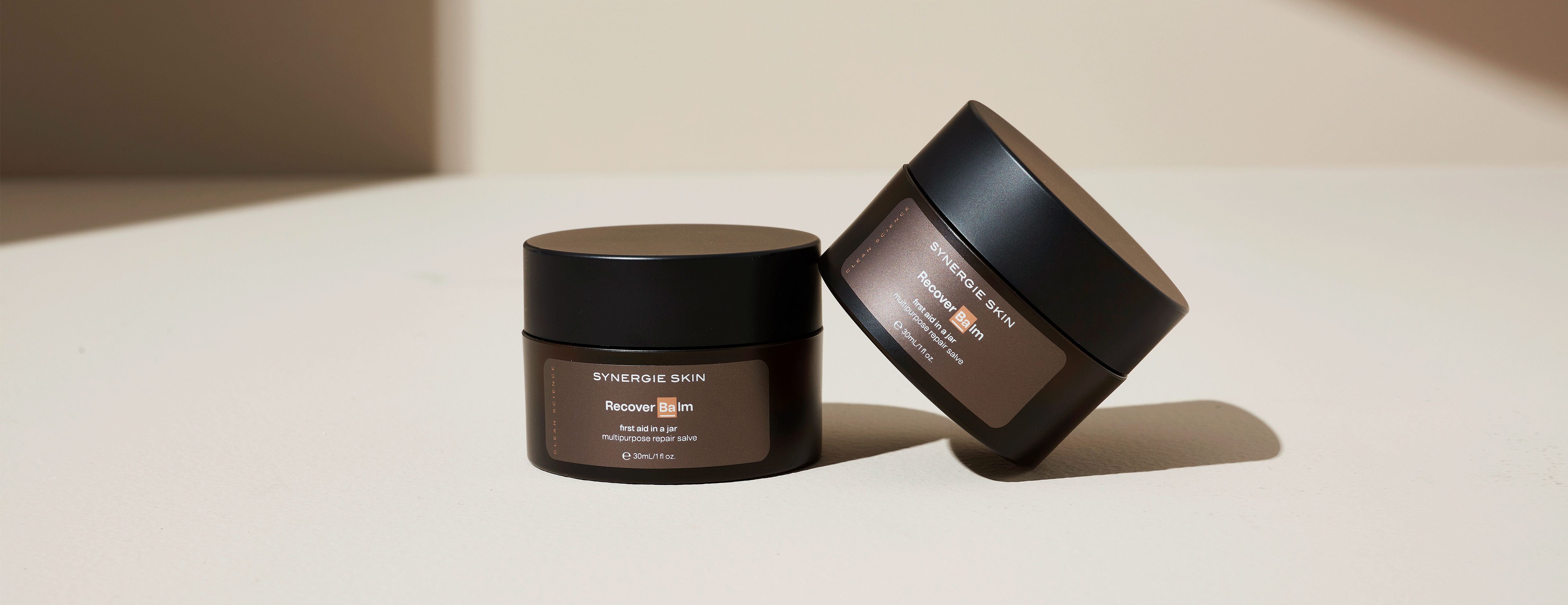 Two Synergie Skin Recover Balm products next to eachother
