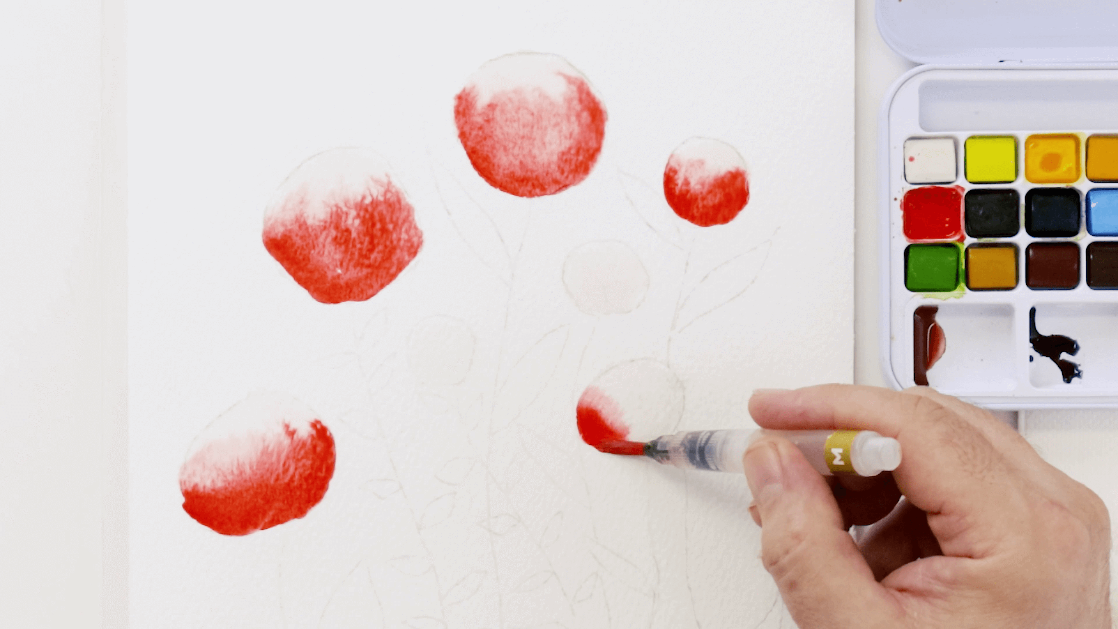 A hand holding a watercolour brush adds the colour Scarlet to the flower bud drawing.