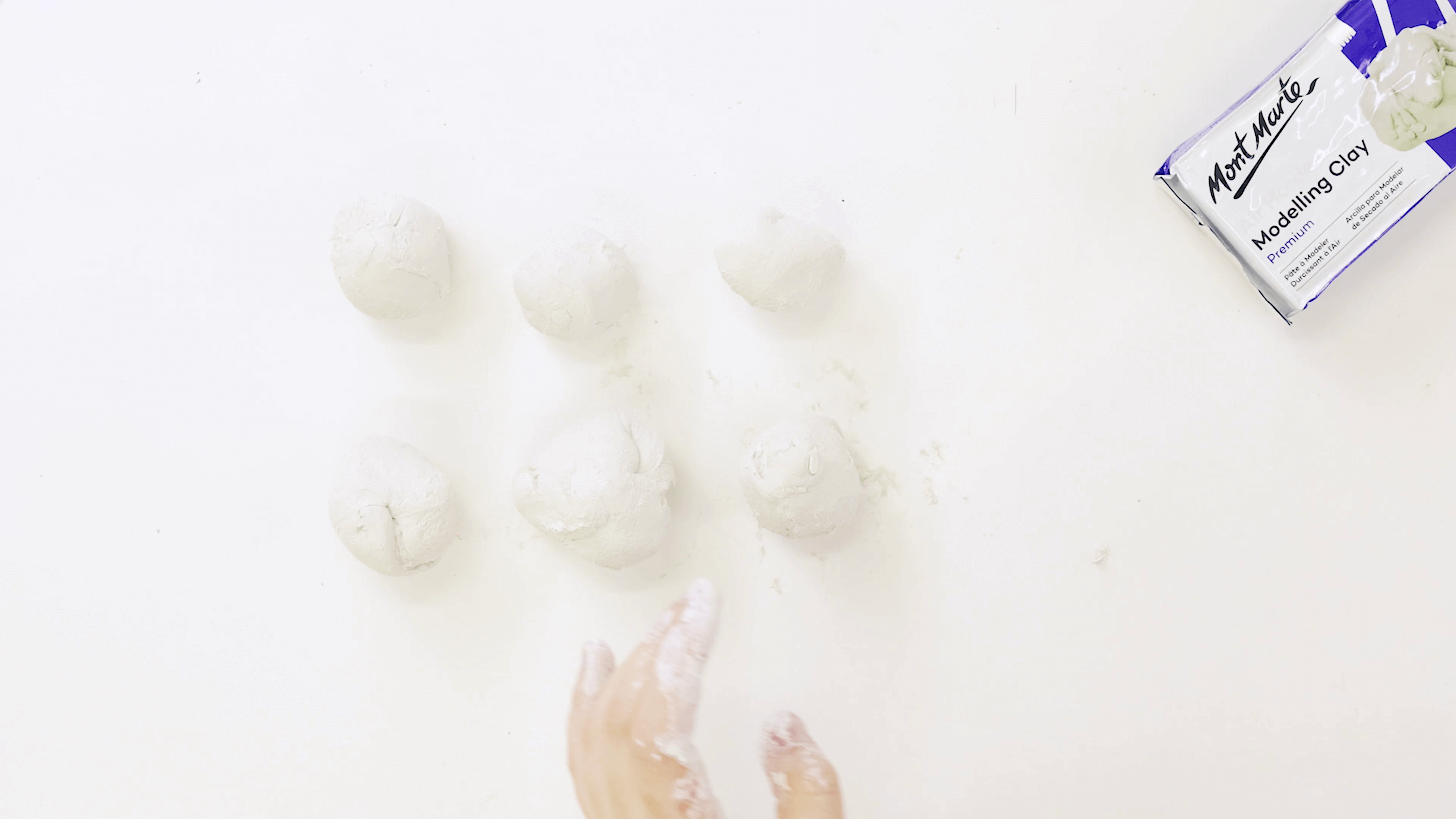 Hand rolling the air dry clay into six balls.