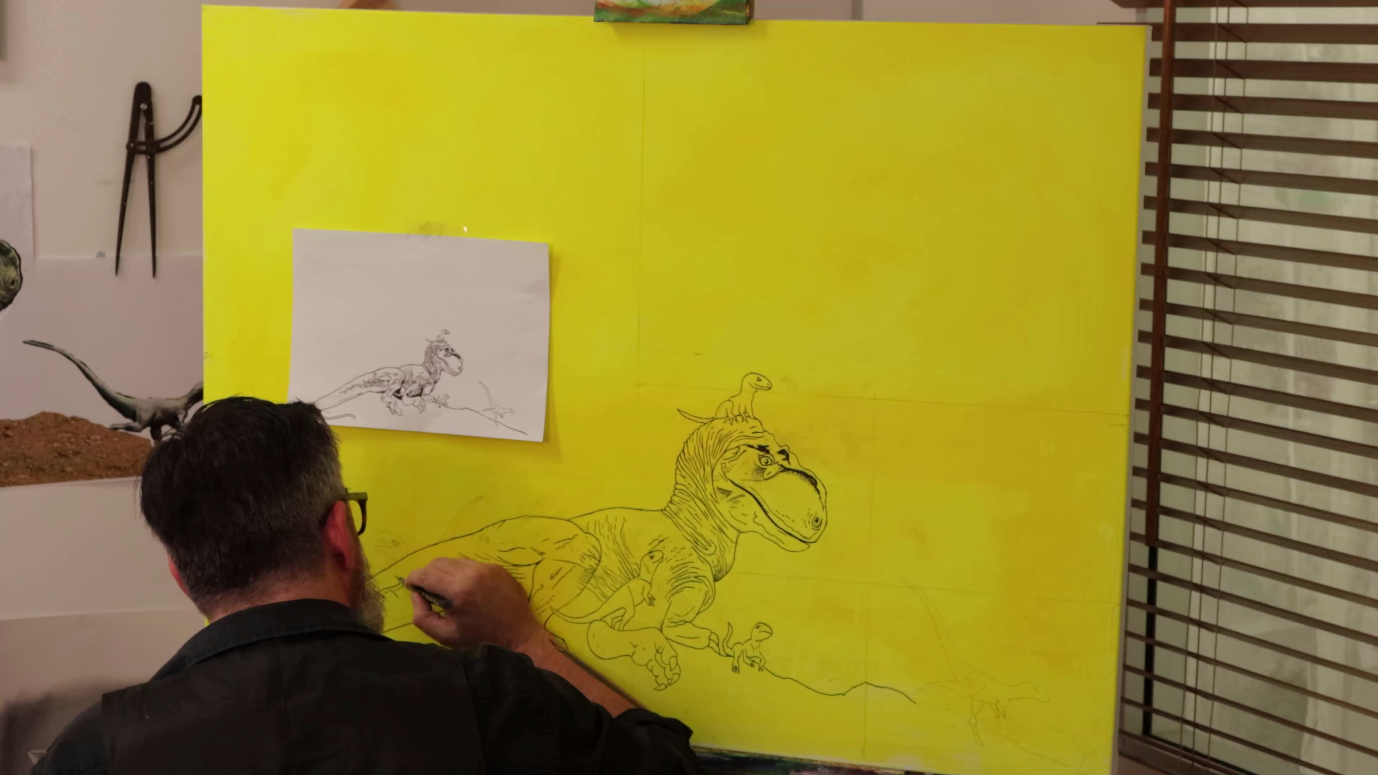 A person drawing a dragon on a yellow wallDescription automatically generated