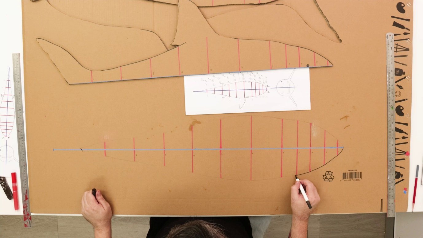 A person drawing on a cardboard boardAI-generated content may be incorrect.