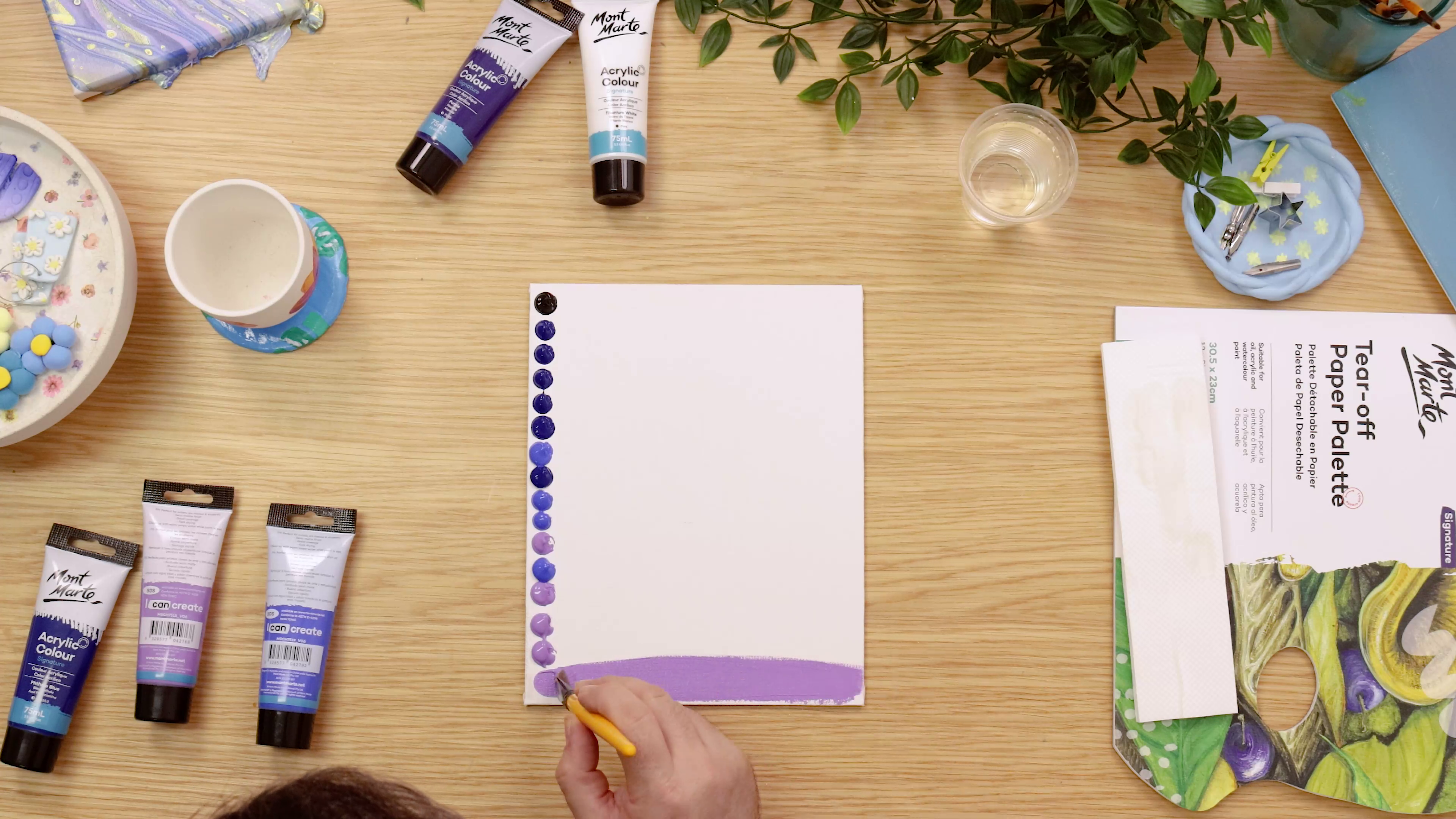 Dots of purple and blue paint on one side of canvas panel