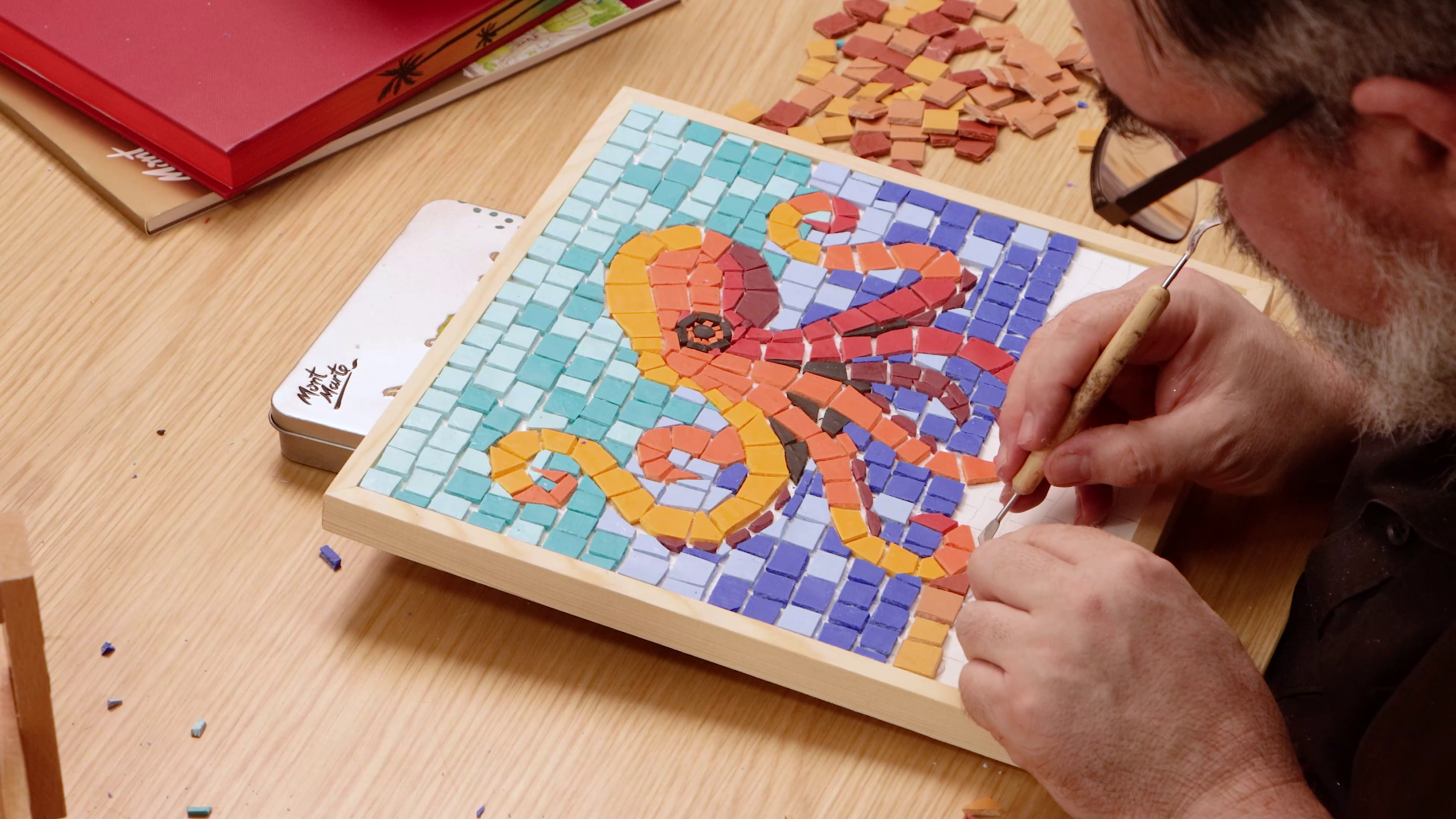 Pressing clay tiles onto framed canvas