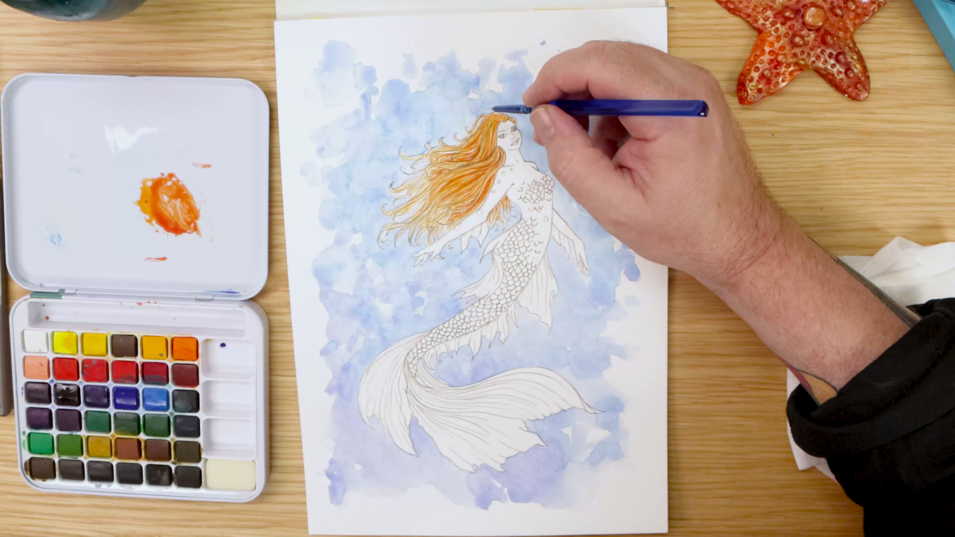 Painting orange hair on watercolour mermaid art