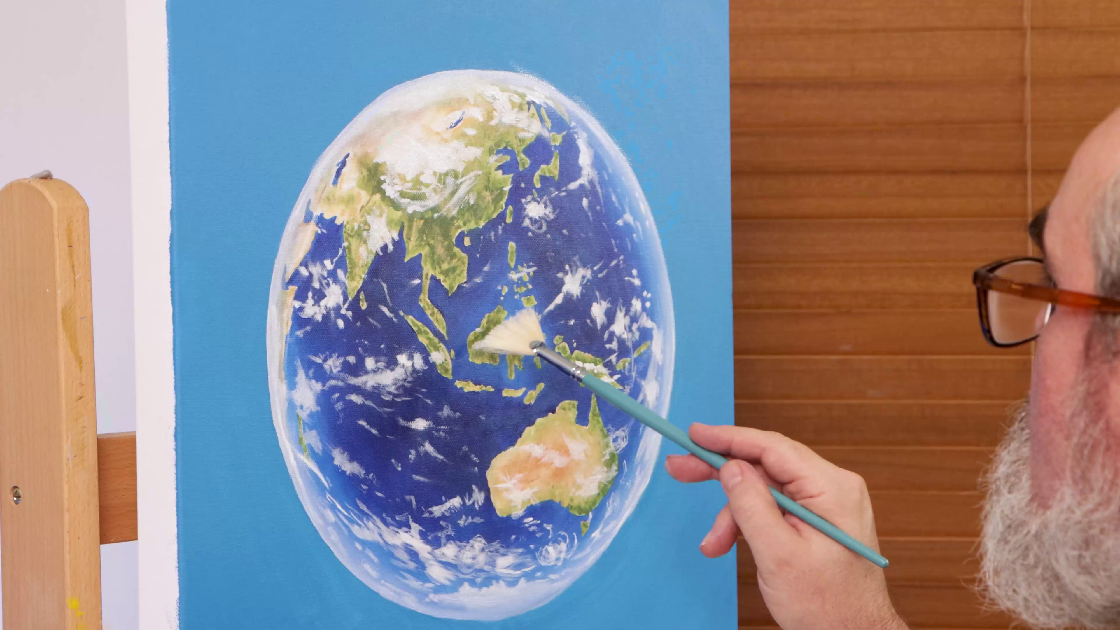 Blending out clouds on earth painting with fan brush