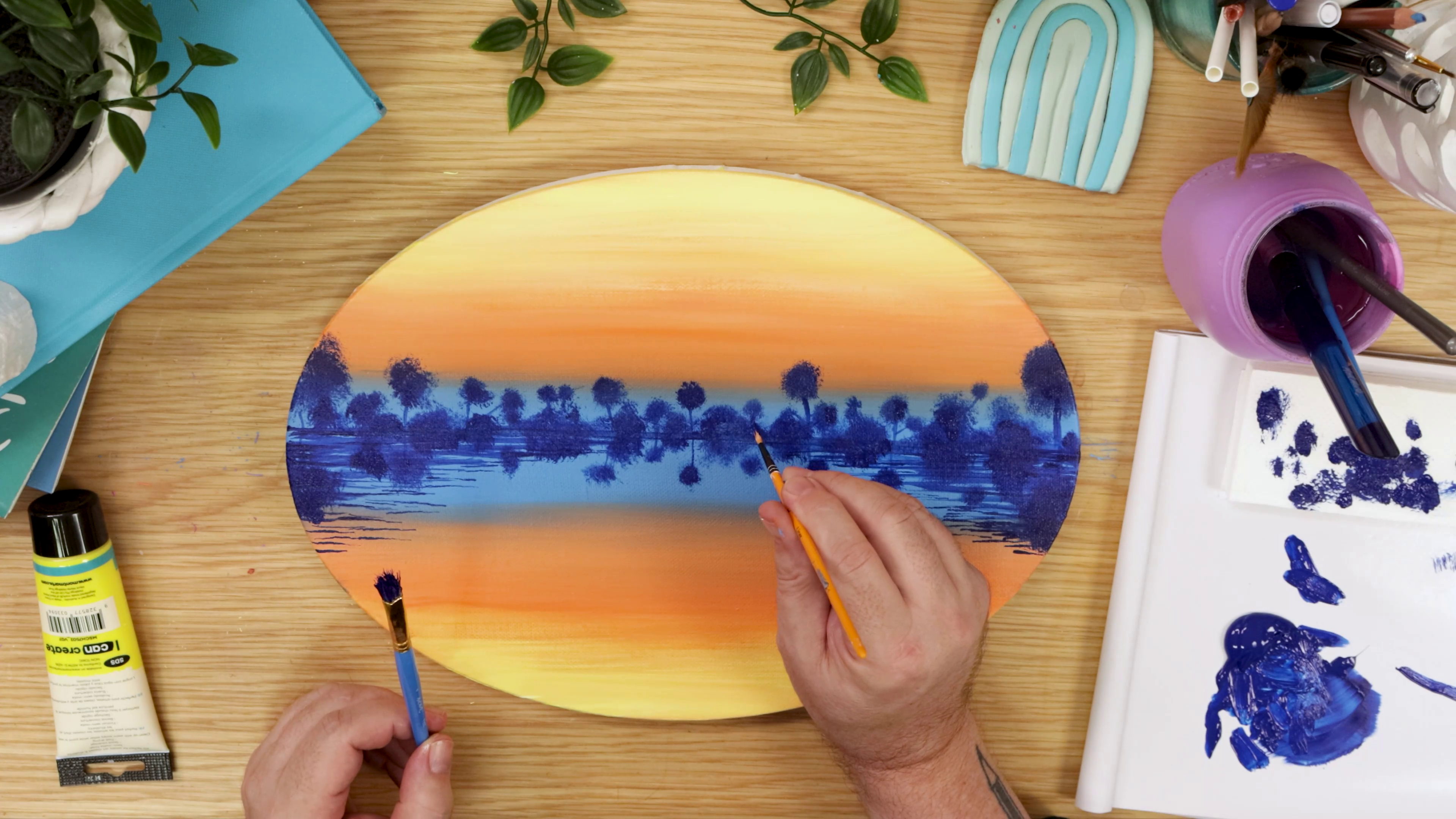 Painting blue tree horizon on oval artwork