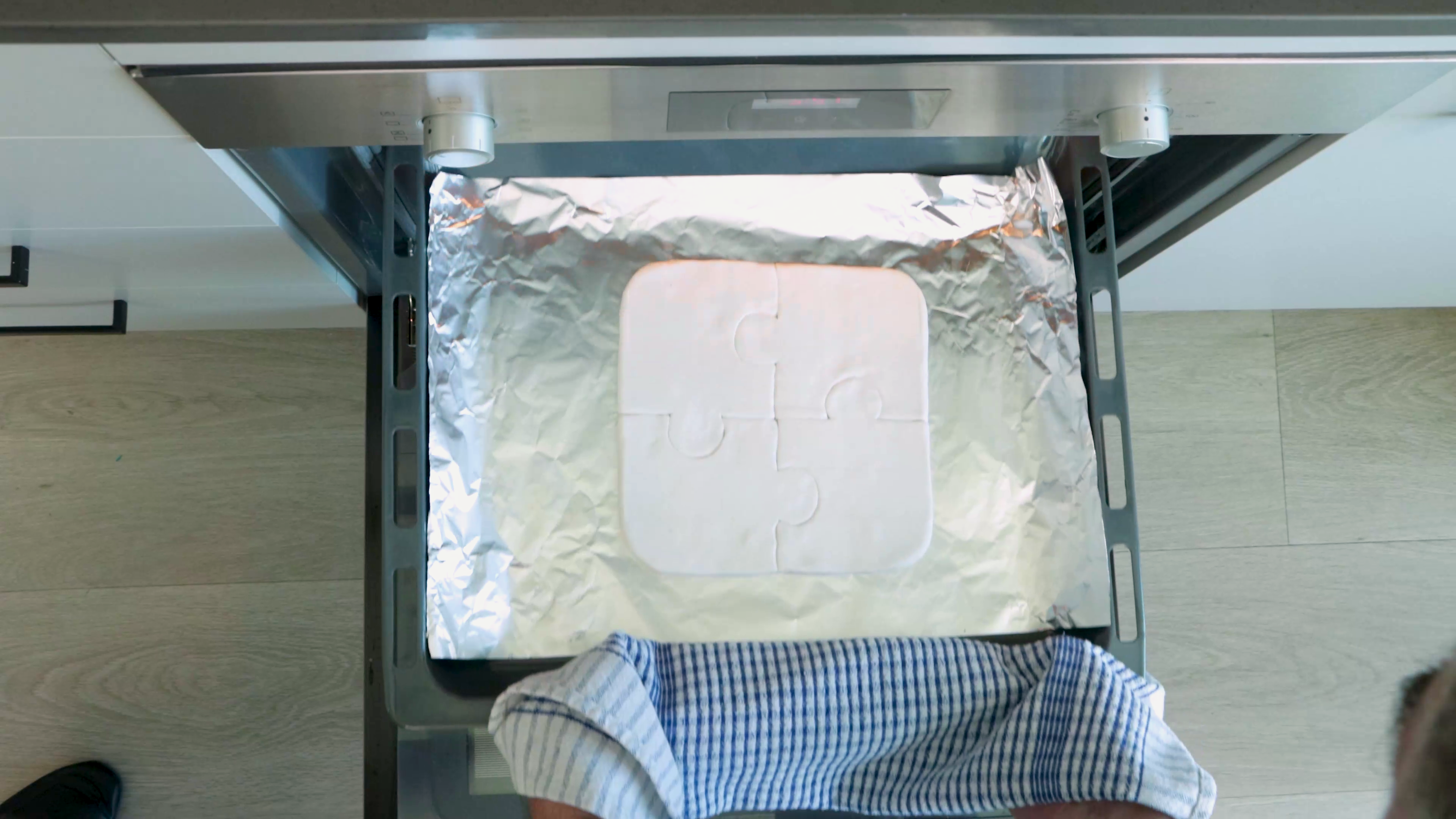 Putting clay puzzle pieces into oven