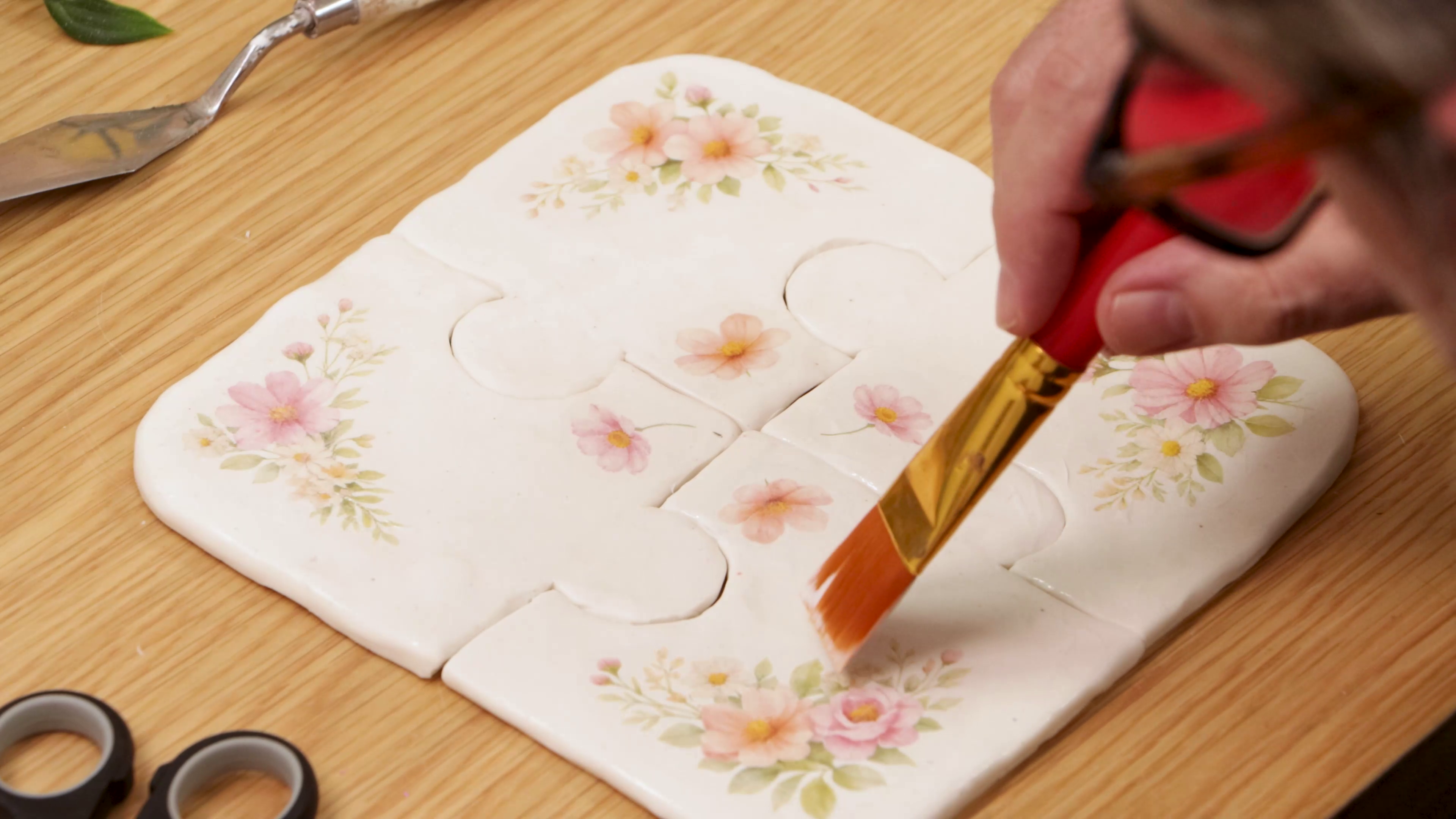 Brush painting Deco Pudge onto floral clay coasters