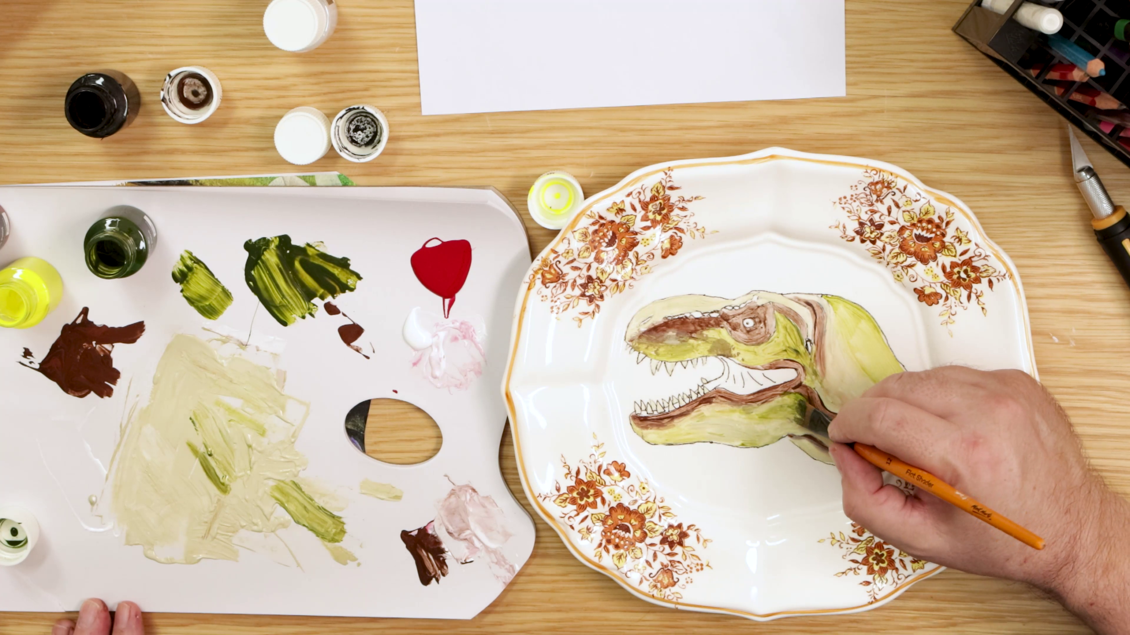 Mapping out colours on dinosaur plate painting
