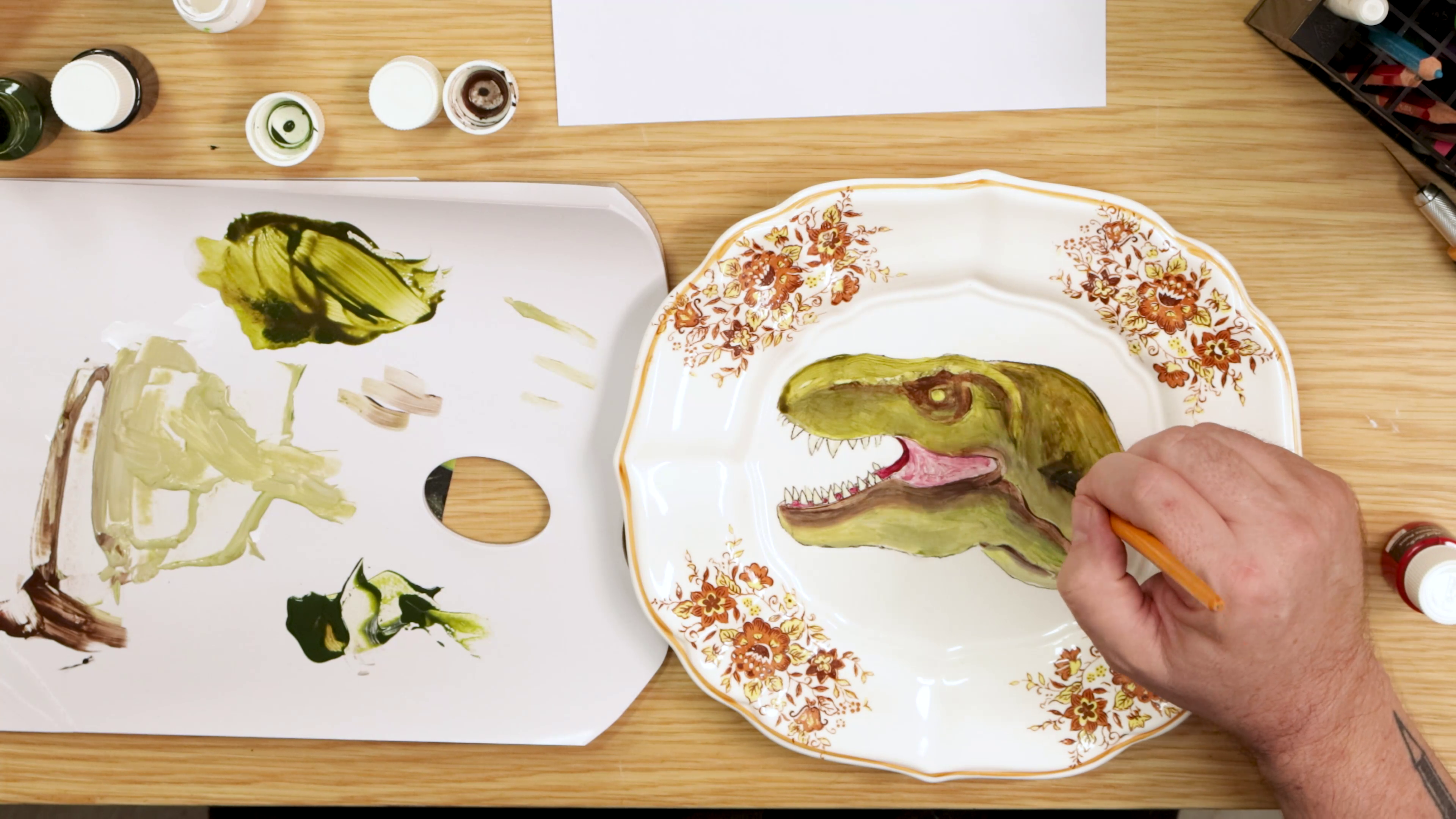 Painting green onto dinosaur plate art