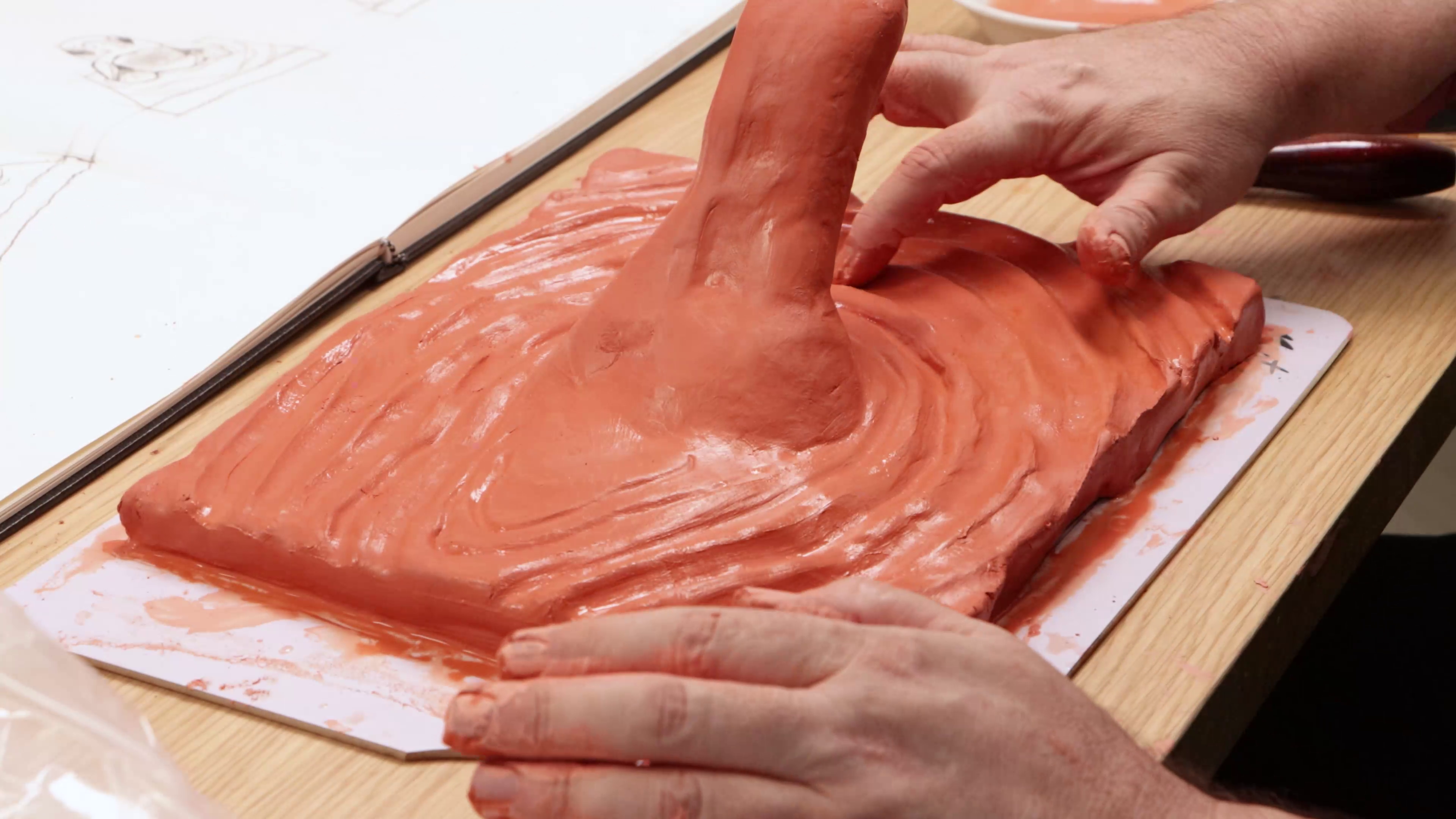 Using fingers to smooth clay water rippling