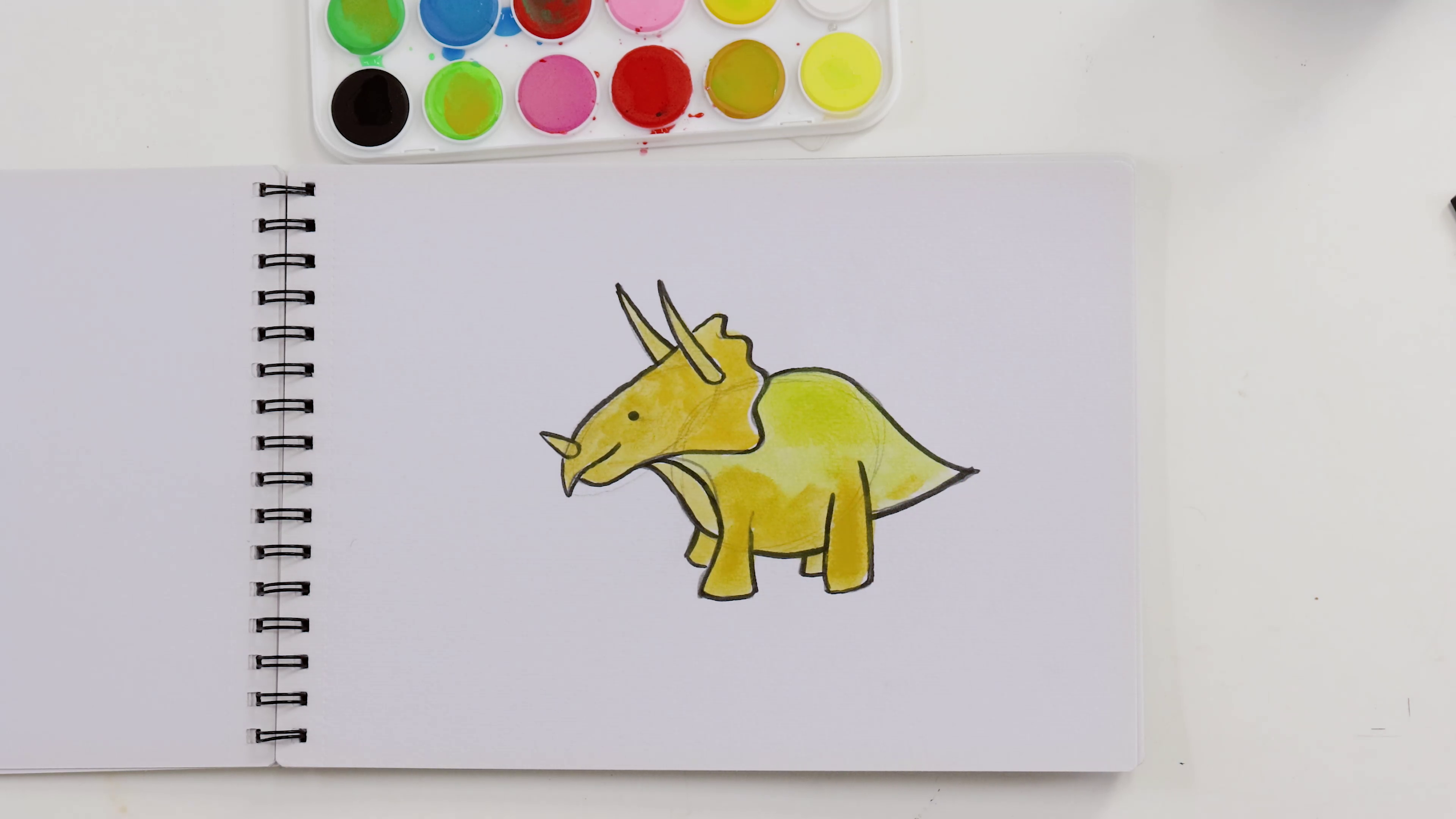 Yellow triceratops watercolour painting on sketchbook