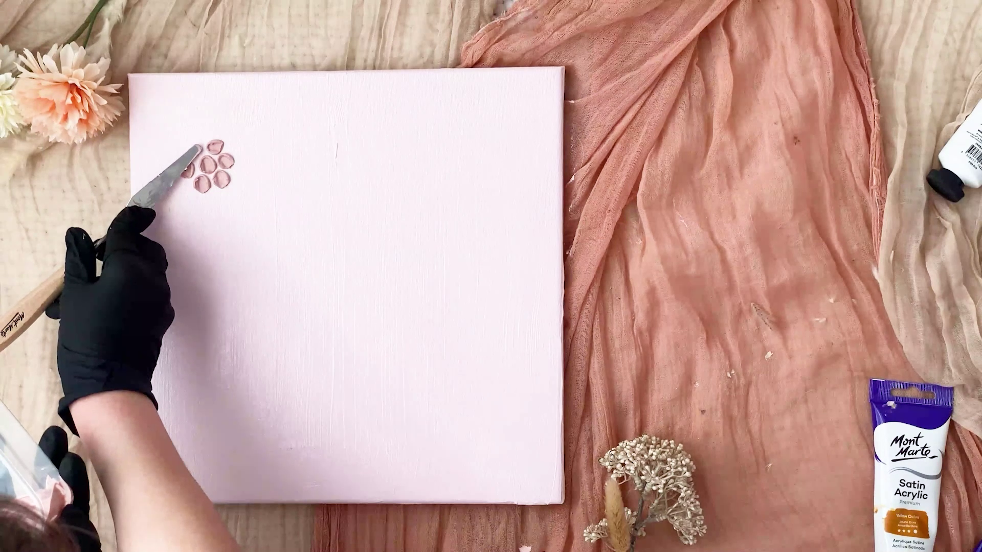 Small dollops of mauve coloured texture paint being made into flowers