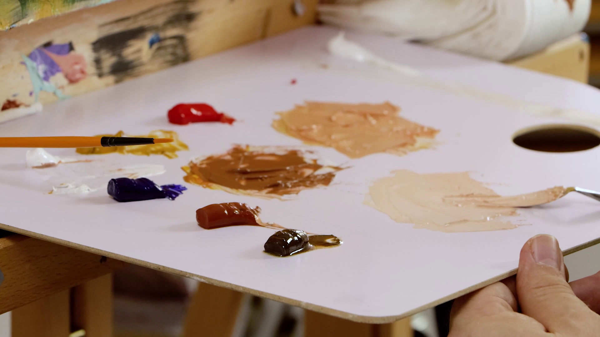 Paint palette with skin tones being mixed in oil paints