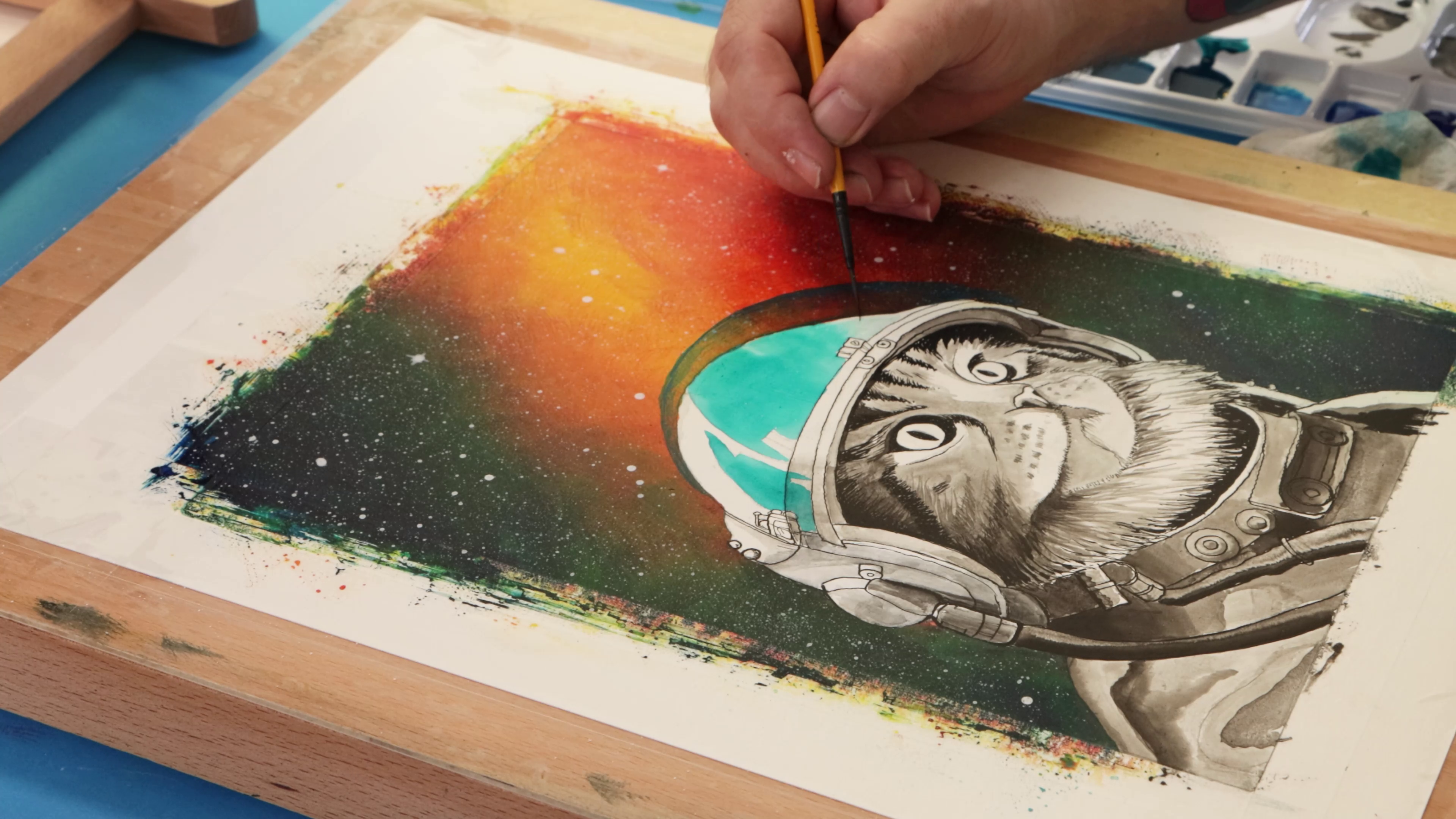 Painting space cat helmet with teal acrylic ink