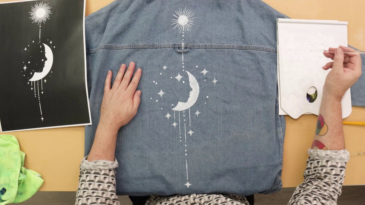 A person's back with a shirt with a moon and stars on itDescription automatically generated