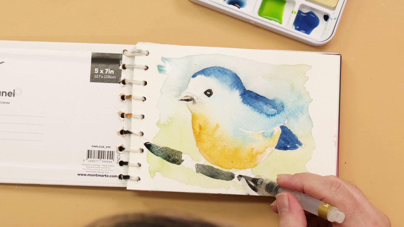 A hand drawing a bird on a sketchbookDescription automatically generated