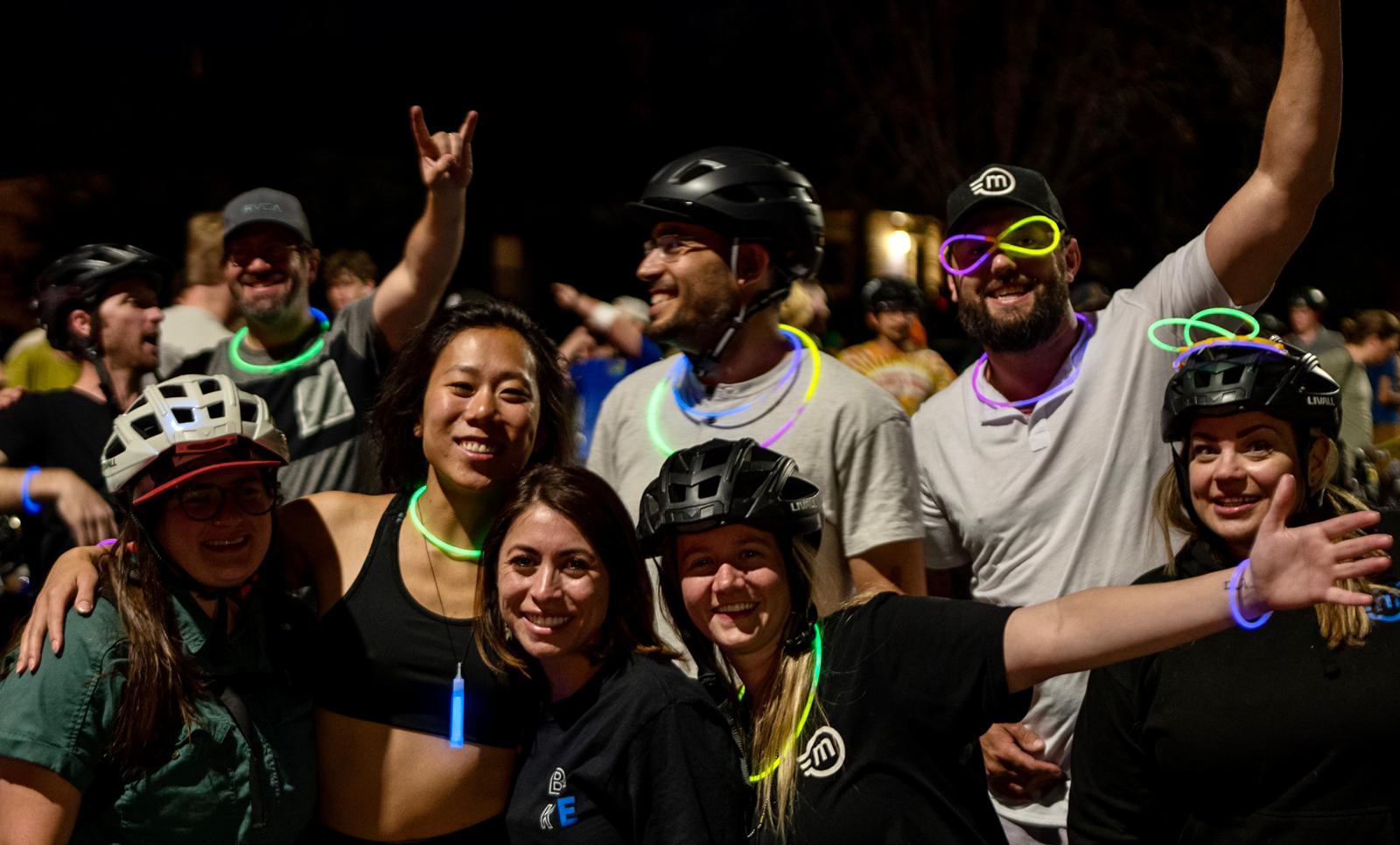group of e-bike riders celebrating at night