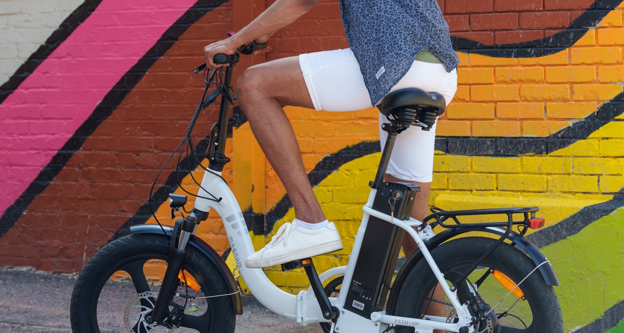 Rider on white Magnum Premium 3 Low Step in front of colorful mural wall