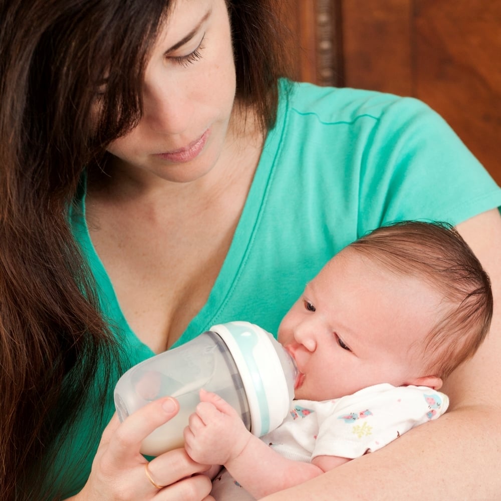Parent with bottle and newborn baby