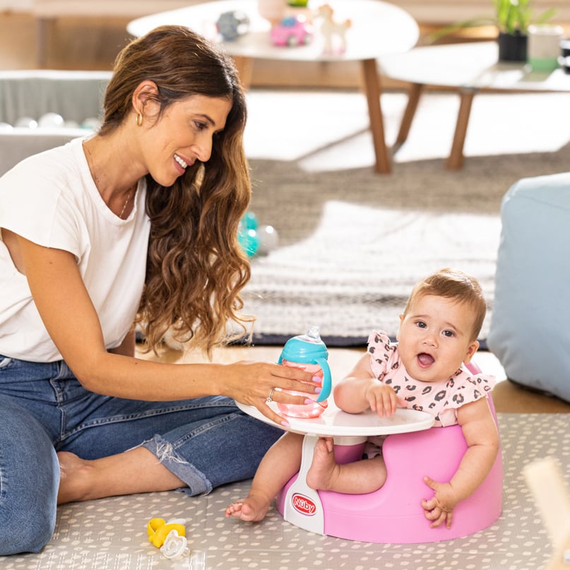 Mom offering a sippy cup to a baby
