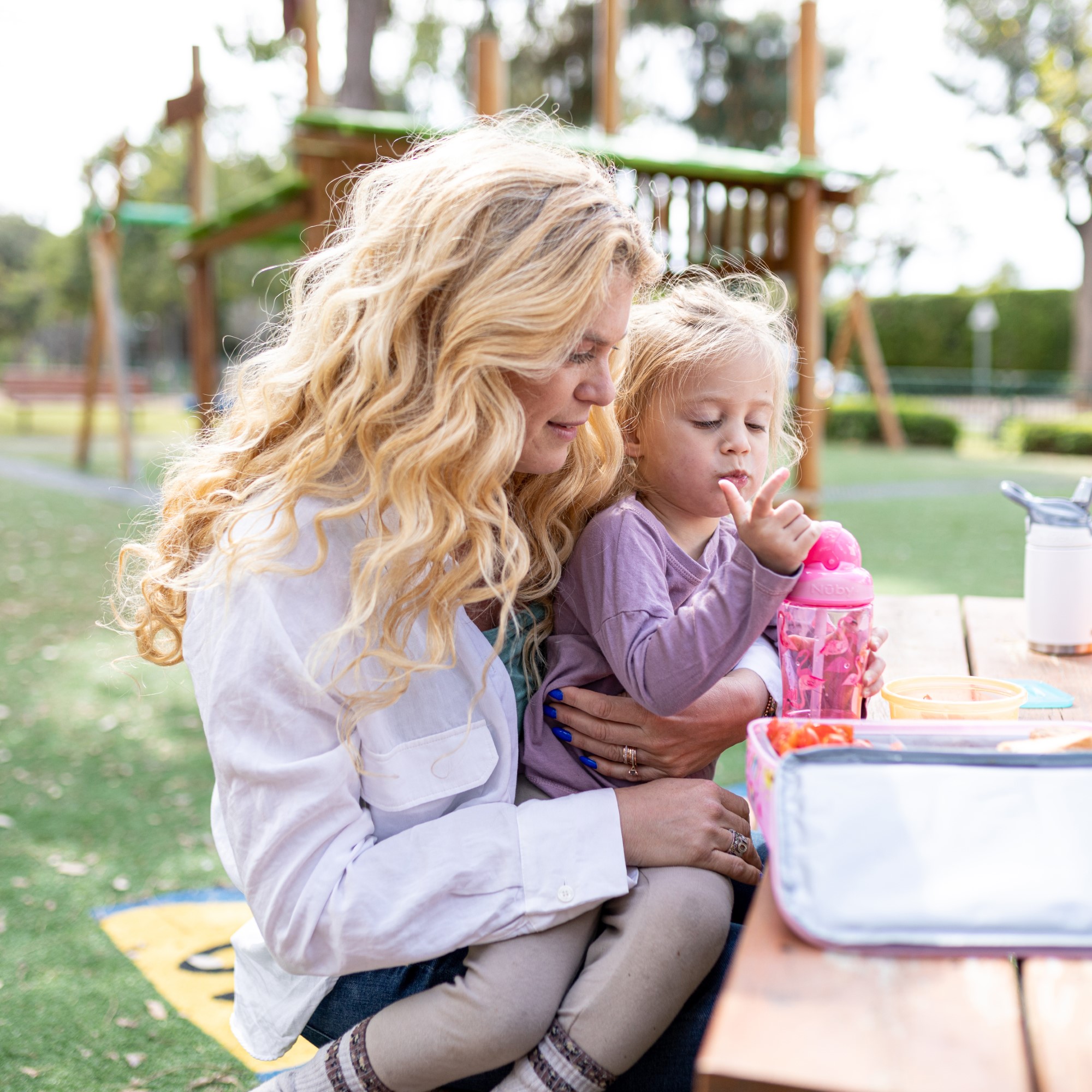 Parent and child sitting at a table with water bottle