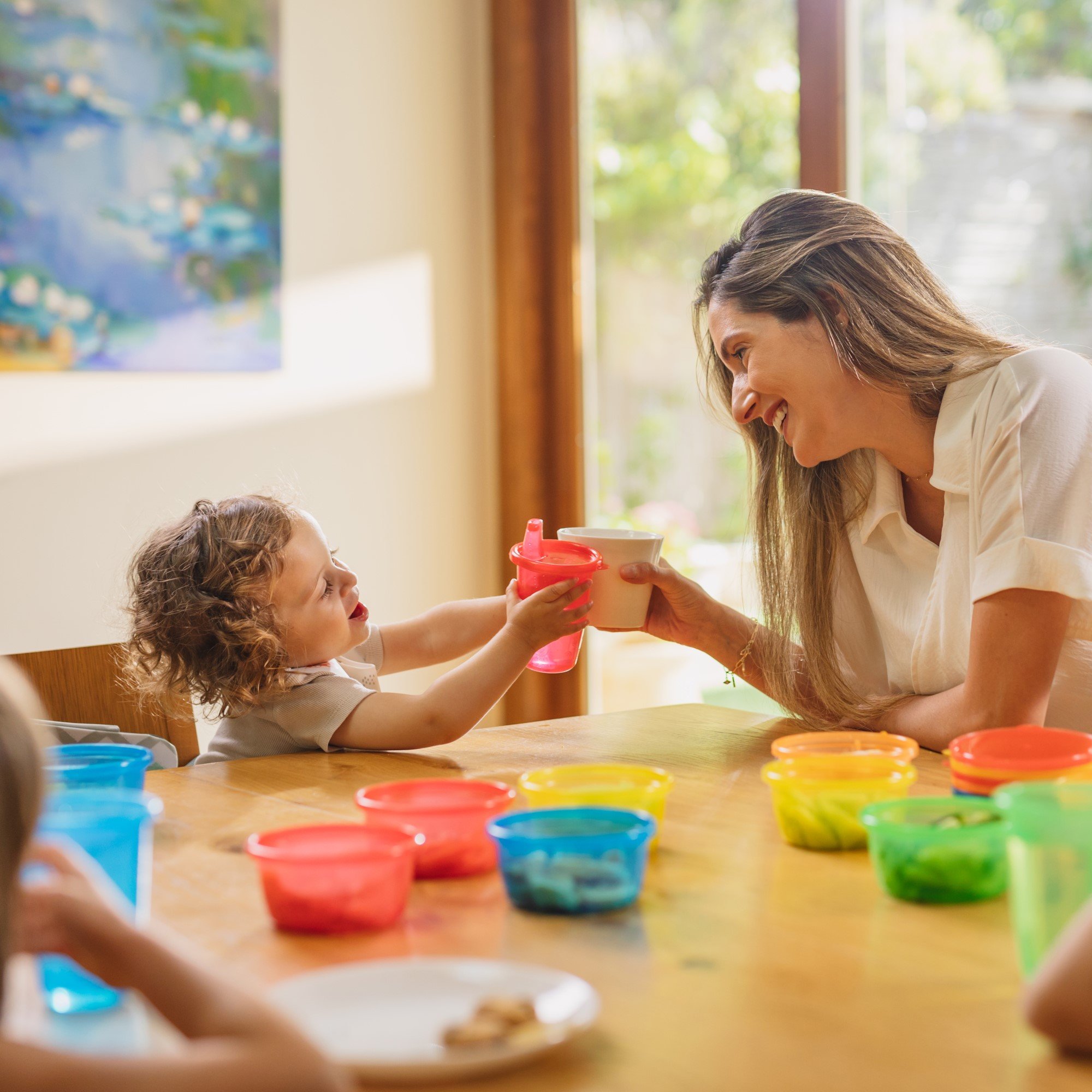 Mother and child sitting at a table with their cups