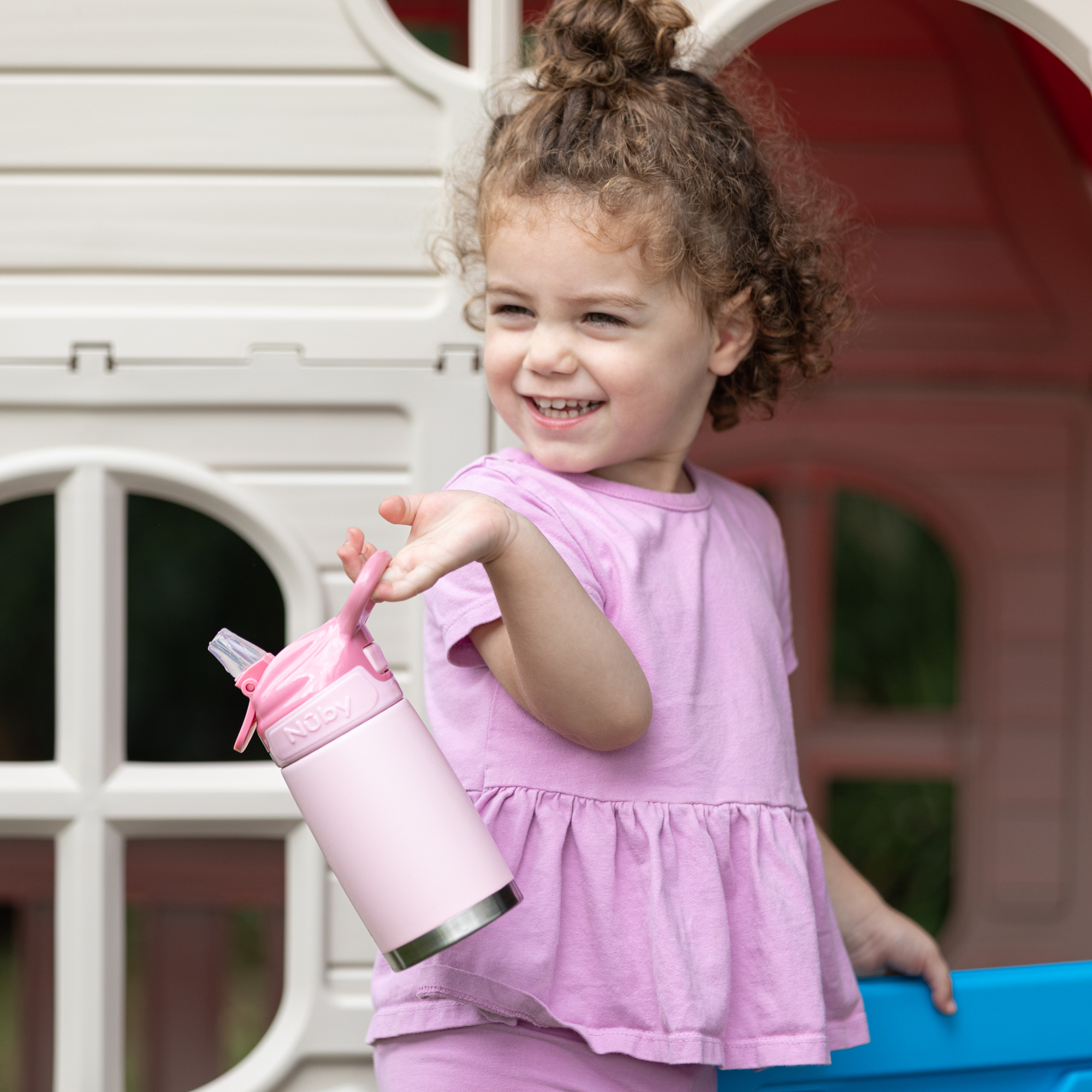 Child with water bottle in the playhouse
