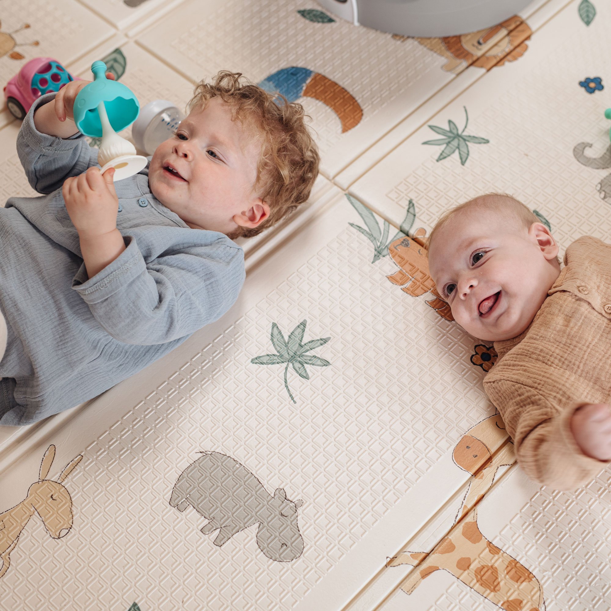 Toddler and baby playing with teether toys