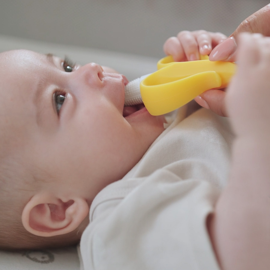 Baby with a banana shaped teether