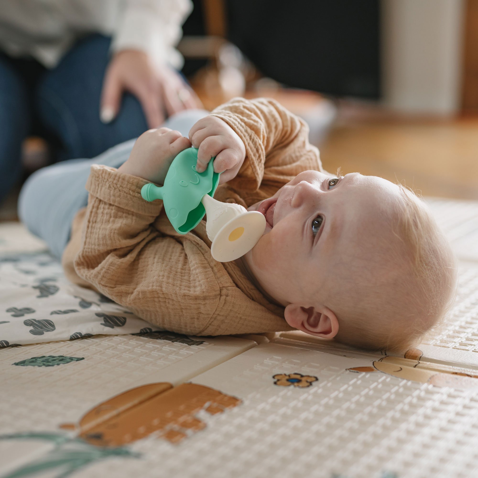 Baby playing with teether on the floor