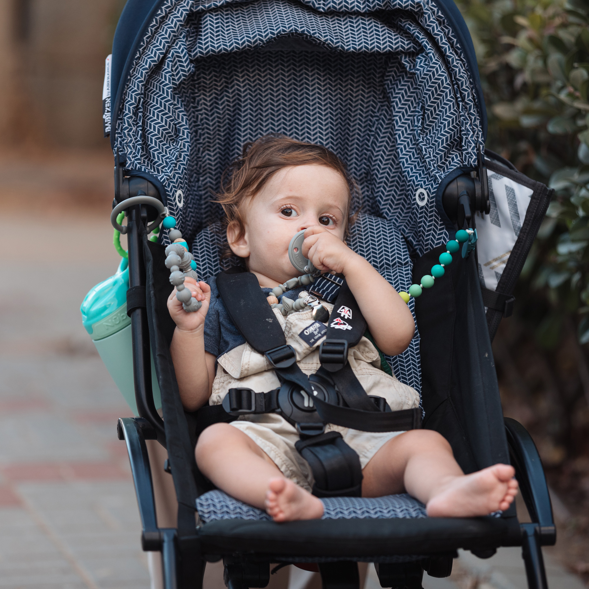 Baby with pacifier while riding a stroller