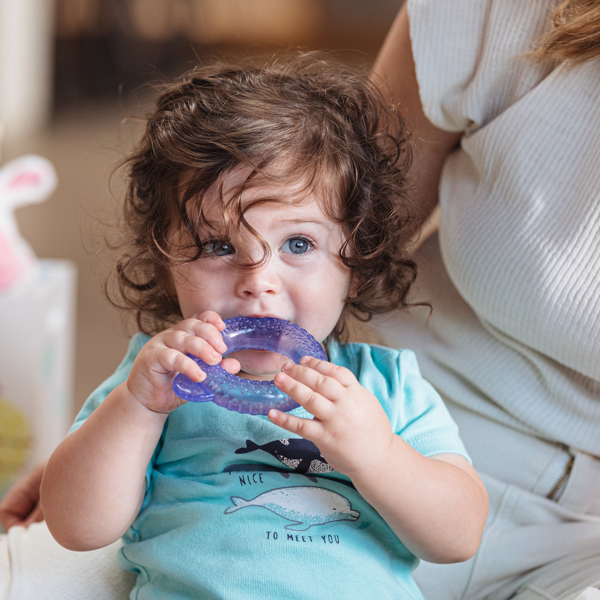 Infant teething on Nuby's Icybite Stacking Cooling Teether Toy.