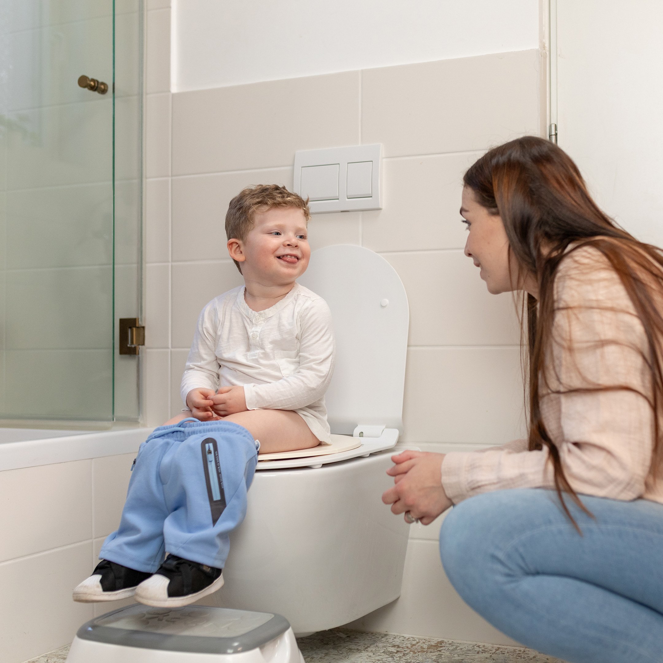 Boy potty training at home with the Nuby Toddler Step Stool in grey.