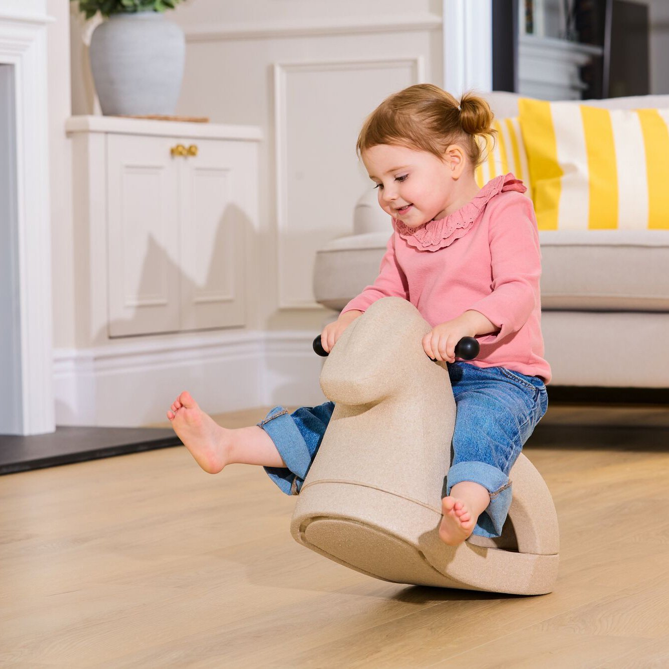 Child playing on the Nuby Rock n' Ride rocking horse while inside.