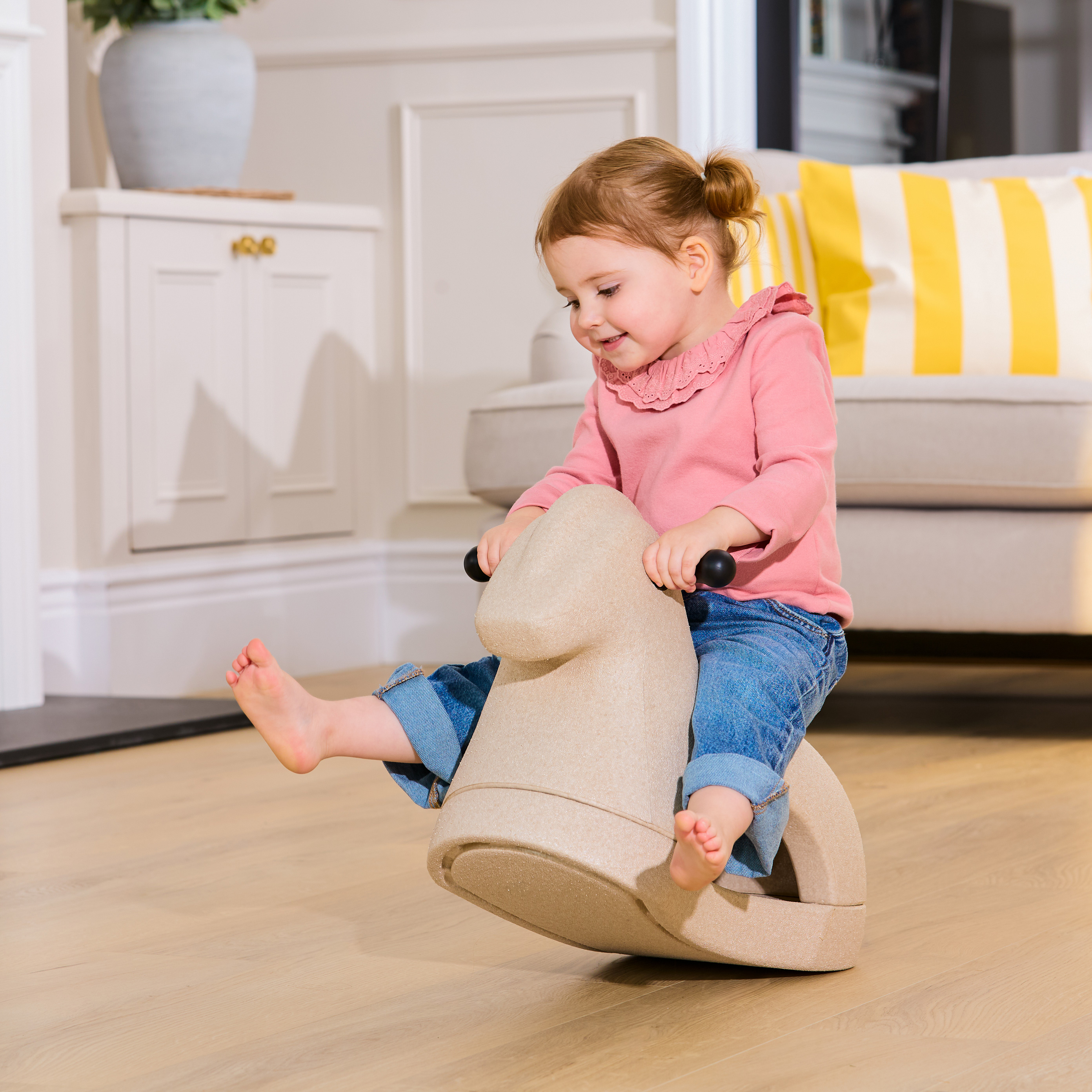 Child playing on the Nuby Rock n' Ride rocking horse while inside.