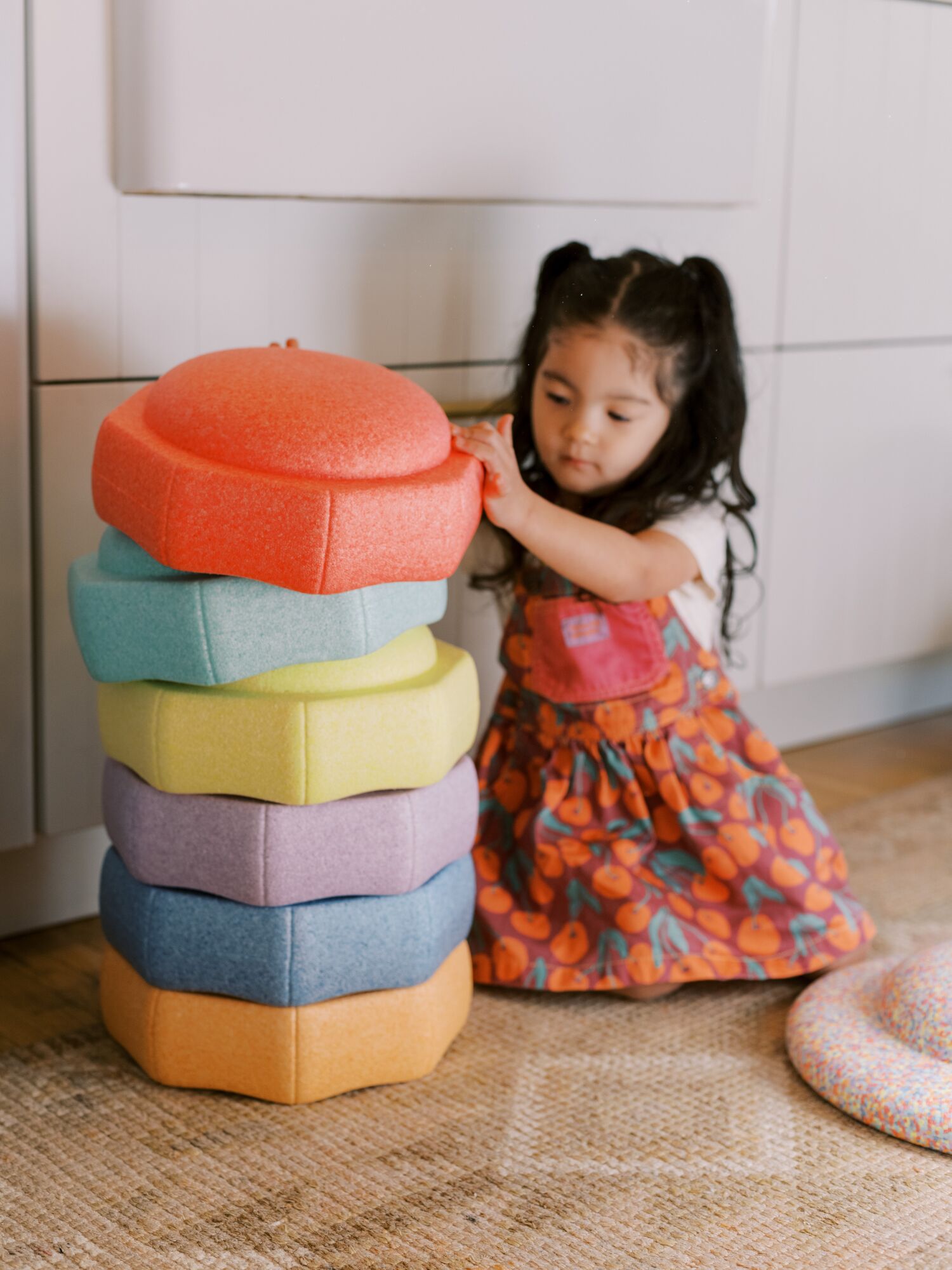 Child learning colors by stacking Nuby StepPebbles.