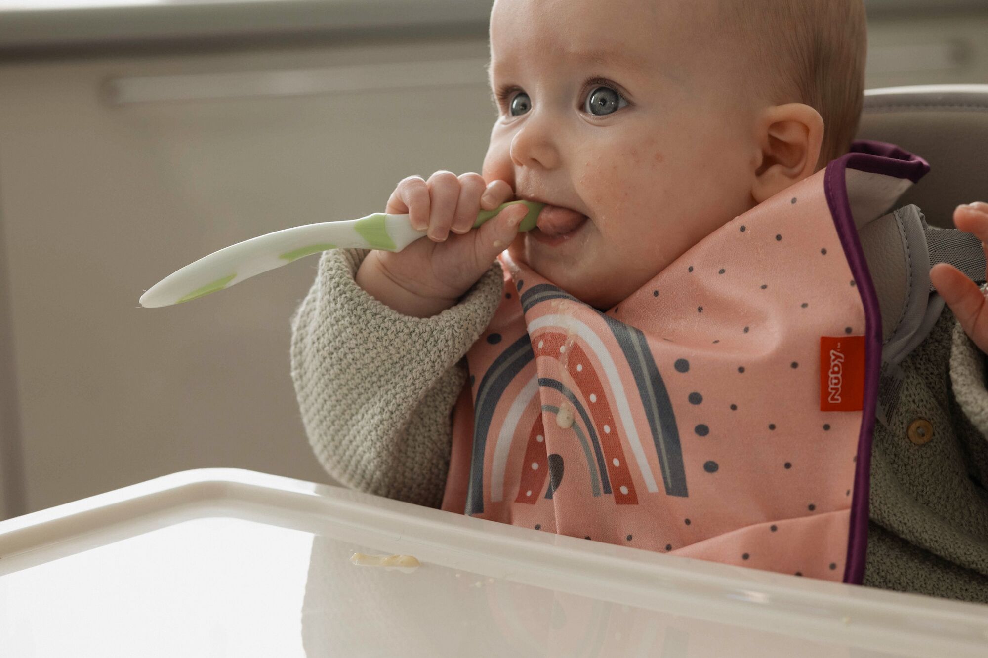 A baby eating a spoonDescription automatically generated