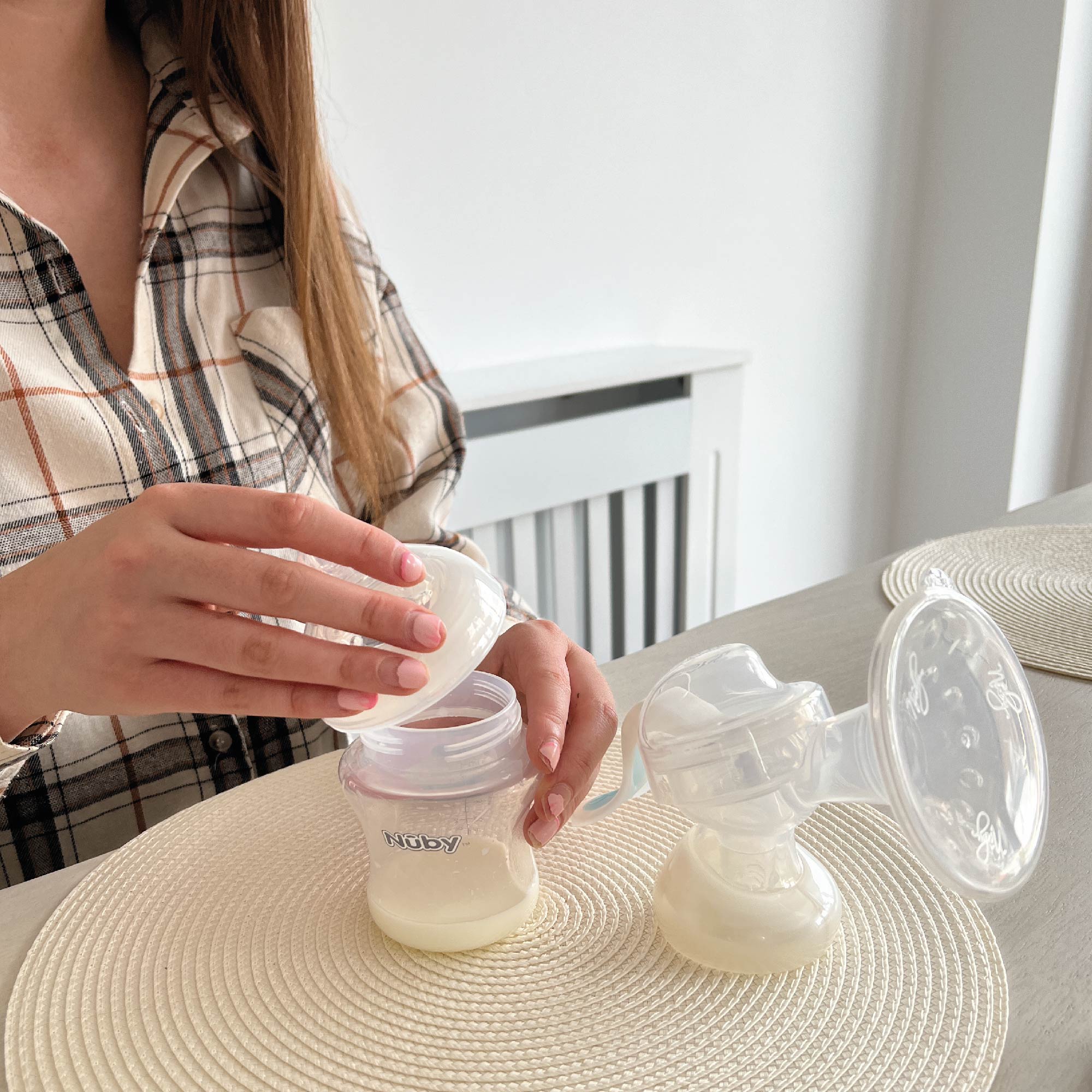 A person pouring milk into a bottleAI-generated content may be incorrect.