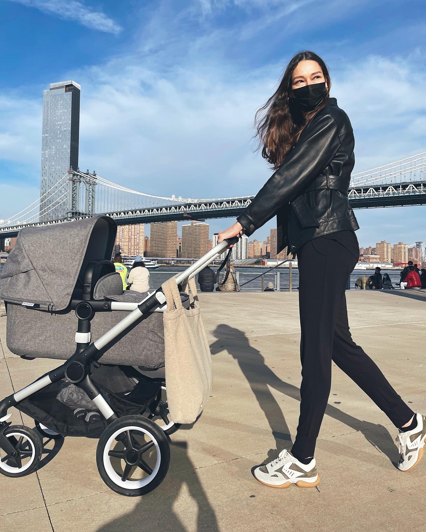 Woman walking baby stroller in New York City. Woman wearing loungewear outside. Woman running errands in NYC.