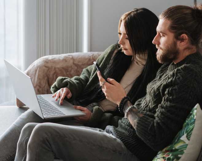 Selecting the Best Weighted Blanket for Couples Sunday Citizen. Couple in a Sofa using their laptop and celphone. 
