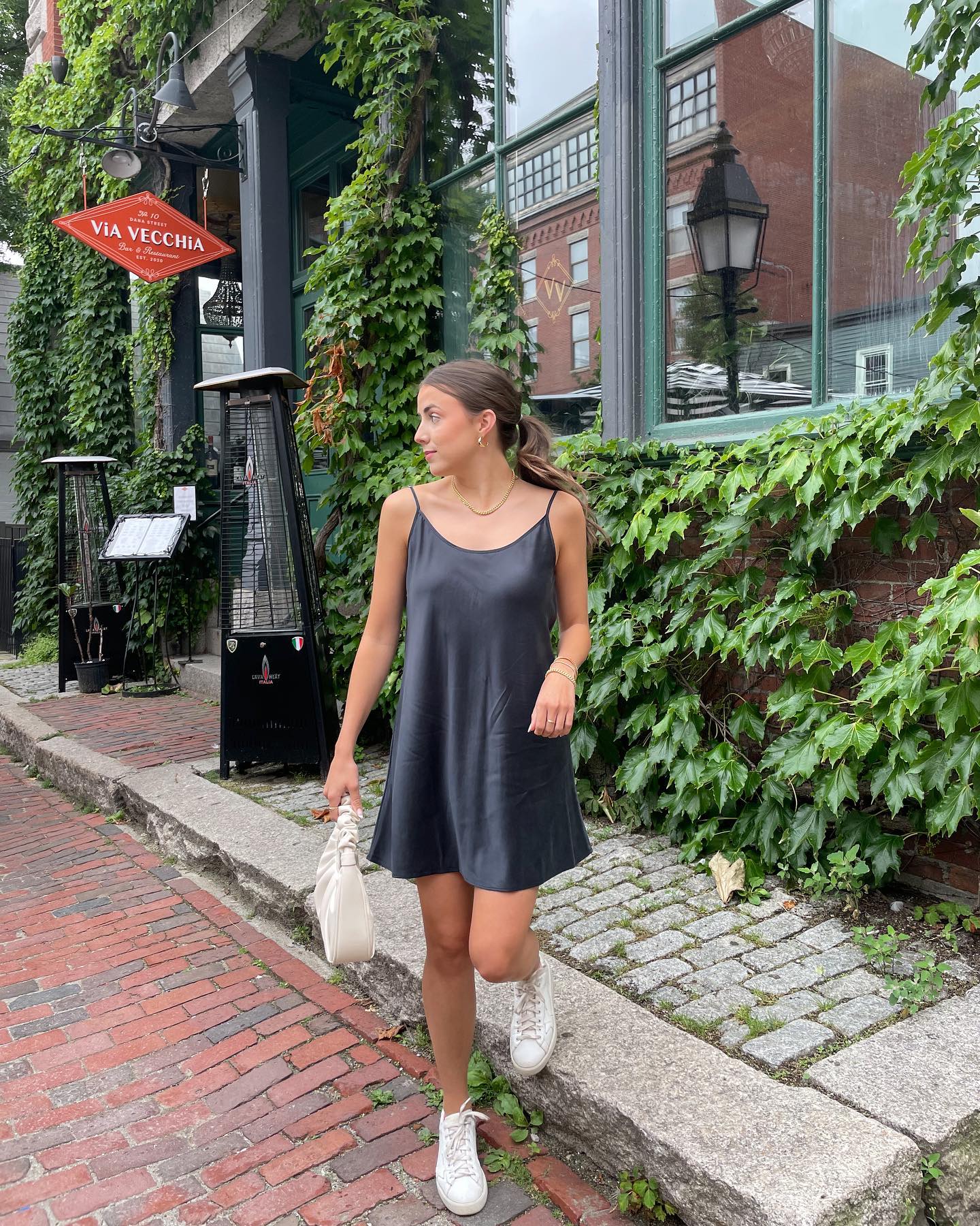 Girl wearing a black washable silk dress outside. Great type of loungewear to wear indoors and outdoors.