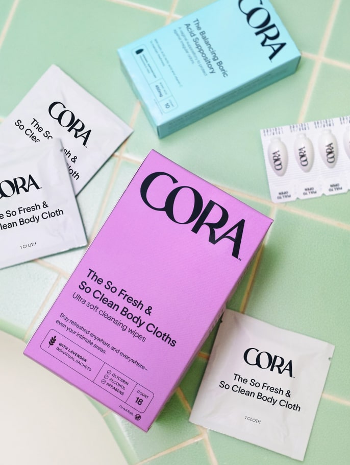 Product photo of the Cora body cloths and boric acid suppository on a tile floor